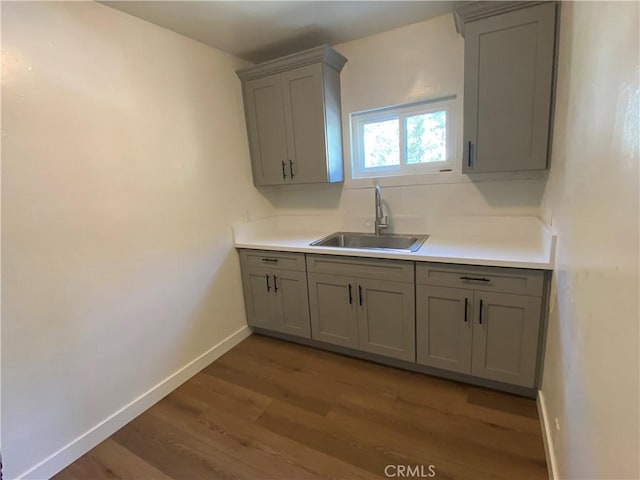 5101 Lindsey Ave, Pico Rivera, CA 90660 - kitchen with gray cabinets, a sink, wood finished floors, and baseboards