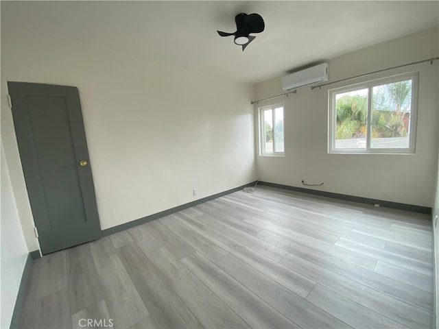 5101 Lindsey Ave, Pico Rivera, CA 90660 - empty room with a wall mounted AC, light wood-style floors, and baseboards