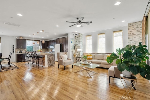 living area with recessed lighting, light wood-style flooring, visible vents, and ceiling fan