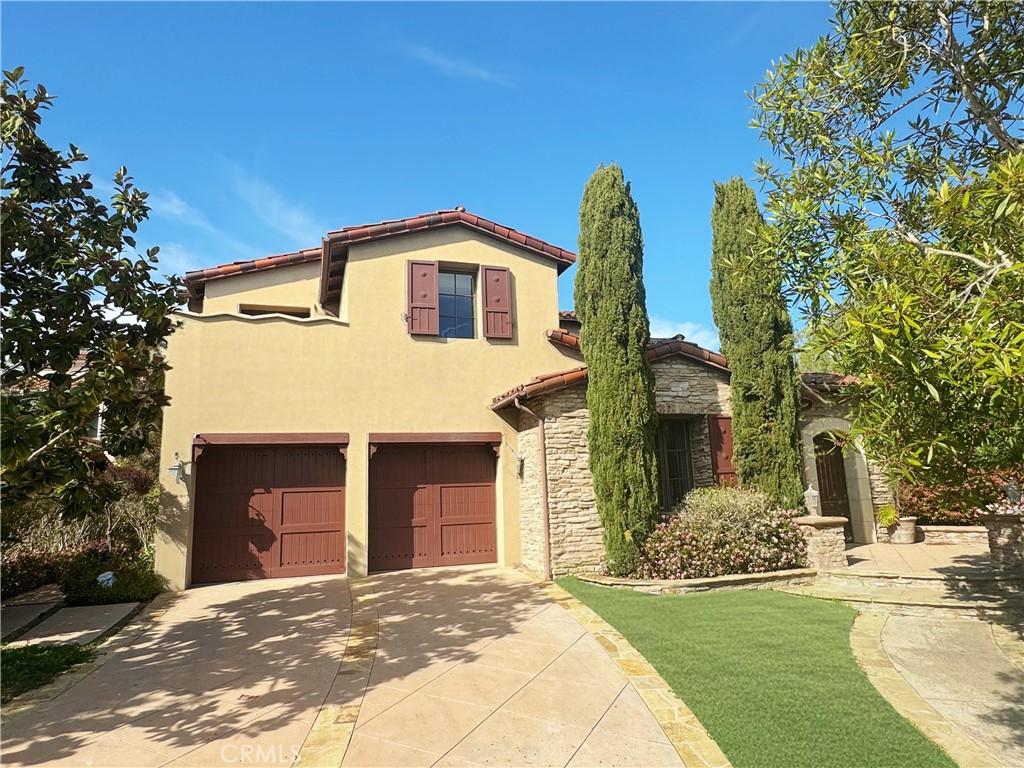 7 Sunrise, Newport Coast, CA 92657 - mediterranean / spanish house with a tile roof, concrete driveway, stone siding, a garage, and stucco siding