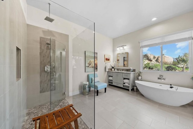bathroom with tile patterned floors, a walk in shower, a freestanding tub, vanity, and visible vents