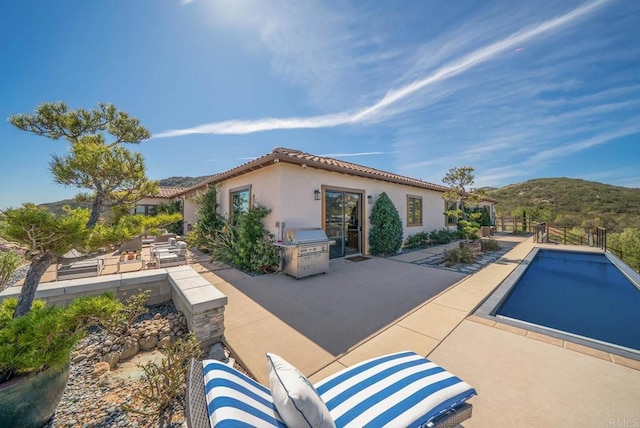 rear view of house with a patio, a mountain view, stucco siding, and fence