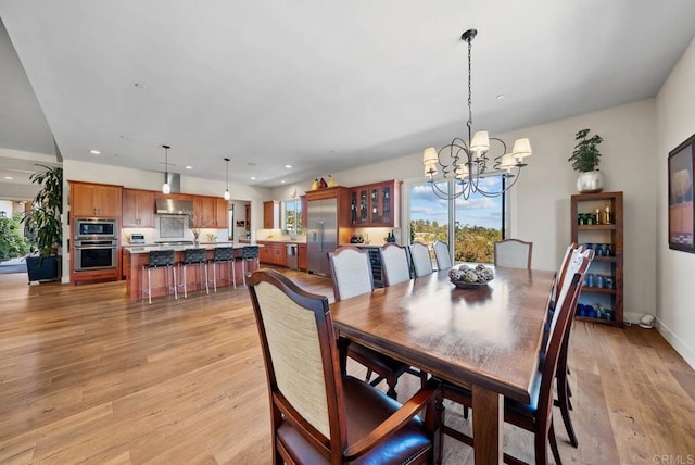 dining room featuring a chandelier, recessed lighting, and light wood-style floors