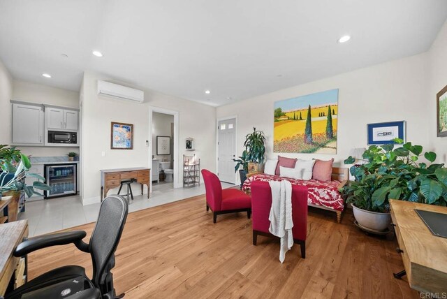 living area with light wood-type flooring, recessed lighting, a wall unit AC, and beverage cooler