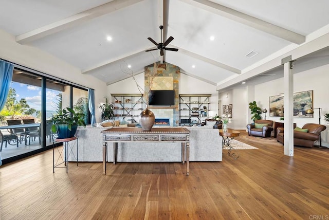 living room featuring visible vents, beam ceiling, wood finished floors, a ceiling fan, and high vaulted ceiling