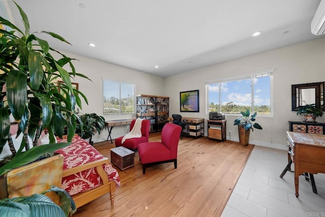 sitting room with baseboards, recessed lighting, and a wall unit AC