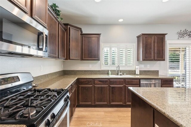 14917 Landerwood Dr, Eastvale, CA 92880 - kitchen with stainless steel appliances, plenty of natural light, a sink, dark brown cabinets, and recessed lighting