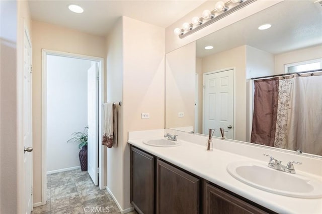 14917 Landerwood Dr, Eastvale, CA 92880 - bathroom featuring double vanity, baseboards, and recessed lighting