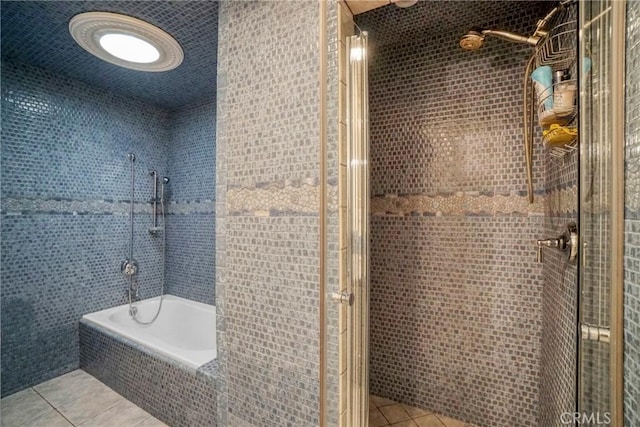 bathroom with tiled shower / bath, tile patterned flooring, and tile walls