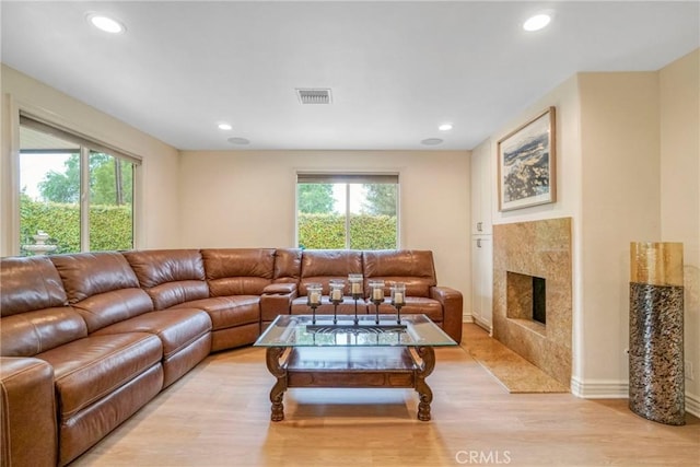 living area featuring recessed lighting, a fireplace, light wood-style floors, and visible vents