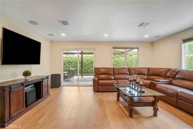 living room featuring visible vents, light wood-type flooring, and recessed lighting