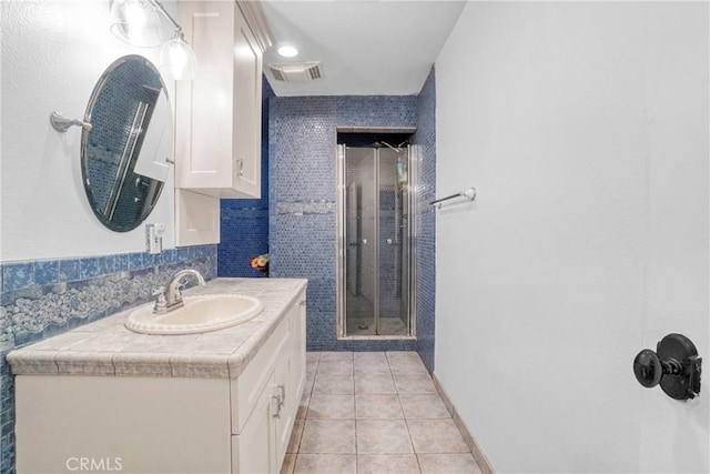 full bathroom featuring vanity, tile patterned flooring, backsplash, a shower stall, and visible vents