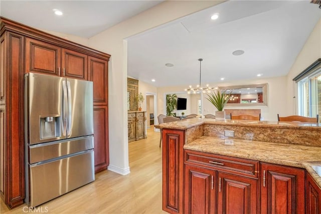 kitchen featuring open floor plan, light wood finished floors, lofted ceiling, and stainless steel refrigerator with ice dispenser