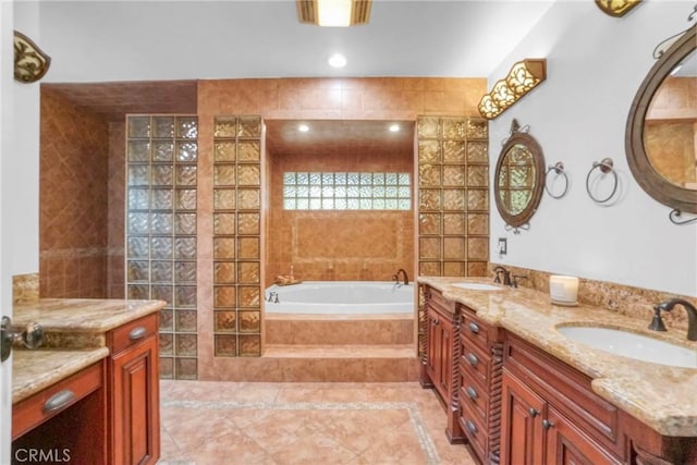bathroom featuring recessed lighting, tile patterned flooring, a garden tub, and a sink