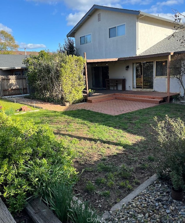 back of property with a yard, stucco siding, fence, and a patio