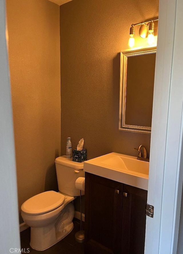 half bathroom featuring toilet and vanity