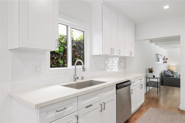 2410 Exposition Pl, Los Angeles, CA 90018 - kitchen with stainless steel dishwasher, light wood-style floors, tasteful backsplash, white cabinetry, and light countertops
