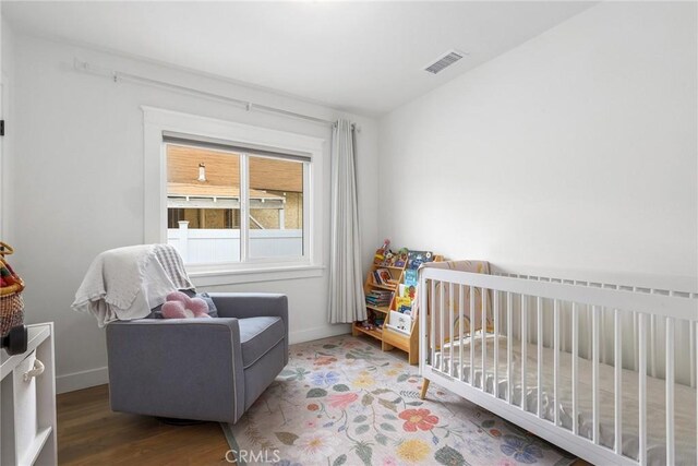 2410 Exposition Pl, Los Angeles, CA 90018 - bedroom with wood finished floors and a crib