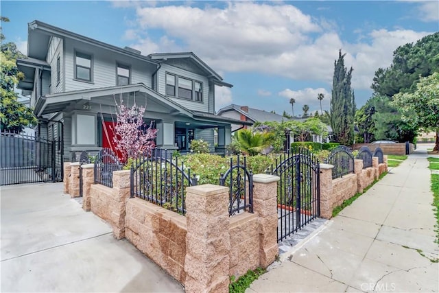 view of side of home with a porch, a gate, and a fenced front yard