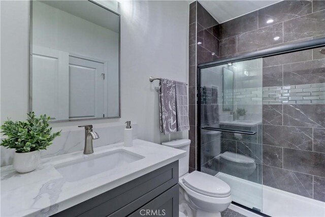 full bathroom with vanity, toilet, and a stall shower