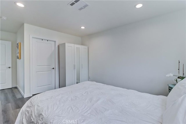 bedroom with visible vents, recessed lighting, baseboards, and wood finished floors