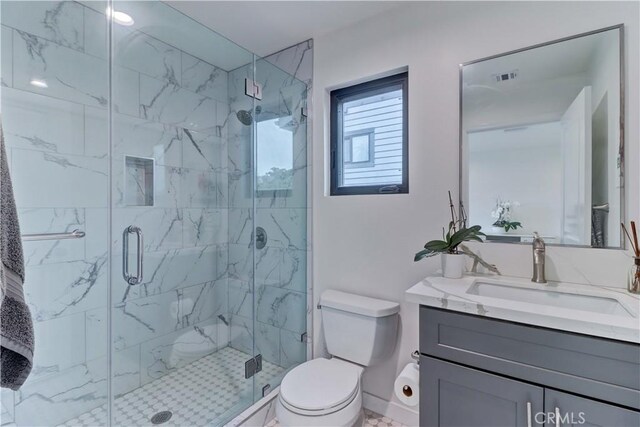 bathroom featuring vanity, visible vents, toilet, and a shower stall