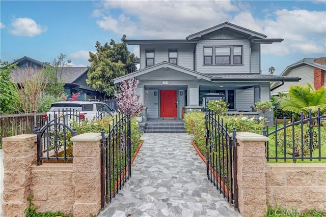 craftsman house featuring a gate, a fenced front yard, and a porch