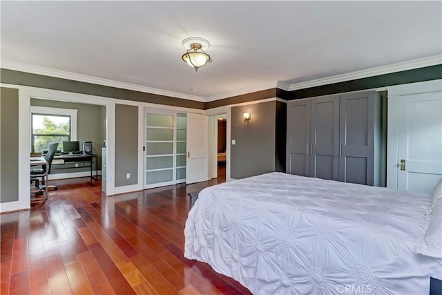 bedroom with crown molding, baseboards, multiple closets, and wood finished floors