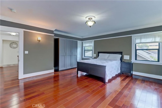 bedroom with baseboards, ornamental molding, and dark wood-style flooring