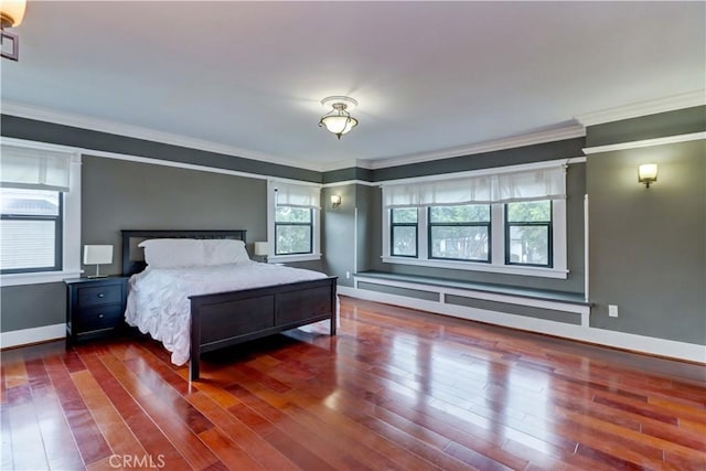 bedroom with crown molding, baseboards, wood finished floors, and visible vents