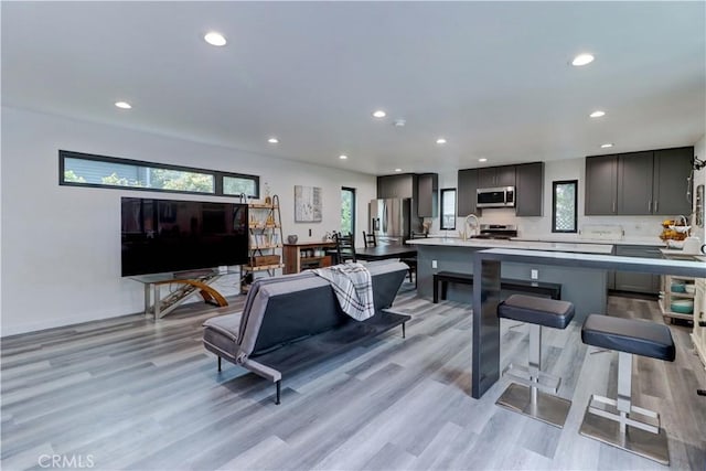living area featuring recessed lighting, light wood-style flooring, and plenty of natural light