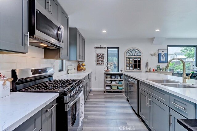 223 N St Andrews Pl, Los Angeles, CA 90004 - kitchen with appliances with stainless steel finishes, gray cabinetry, light stone counters, light wood-style floors, and recessed lighting