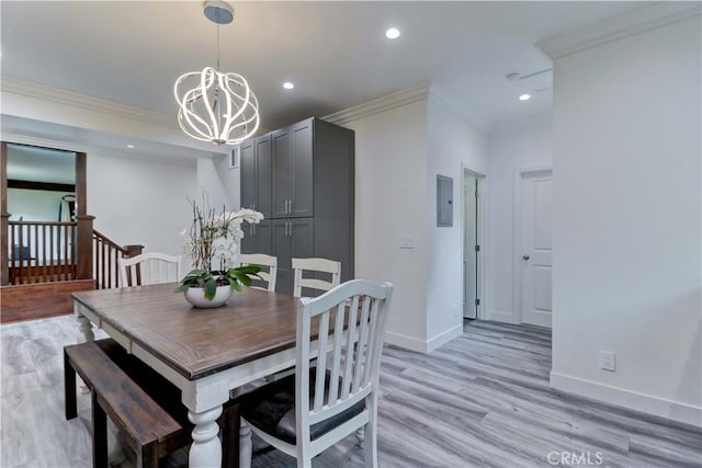 dining room with crown molding, baseboards, light wood-type flooring, electric panel, and a notable chandelier