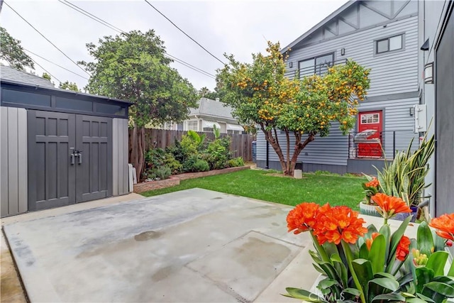 view of patio with an outdoor structure, a fenced backyard, and a shed
