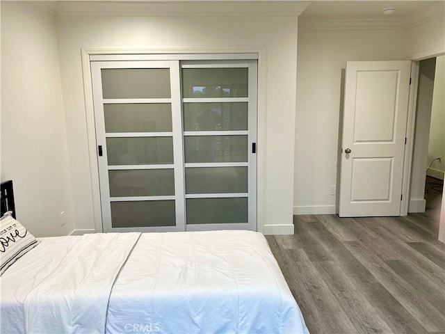 bedroom featuring crown molding, baseboards, and wood finished floors