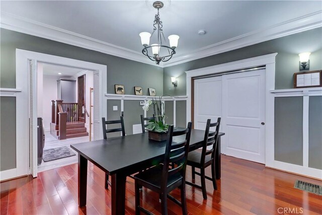 223 N St Andrews Pl, Los Angeles, CA 90004 - dining area with dark wood-type flooring, a chandelier, ornamental molding, and stairs