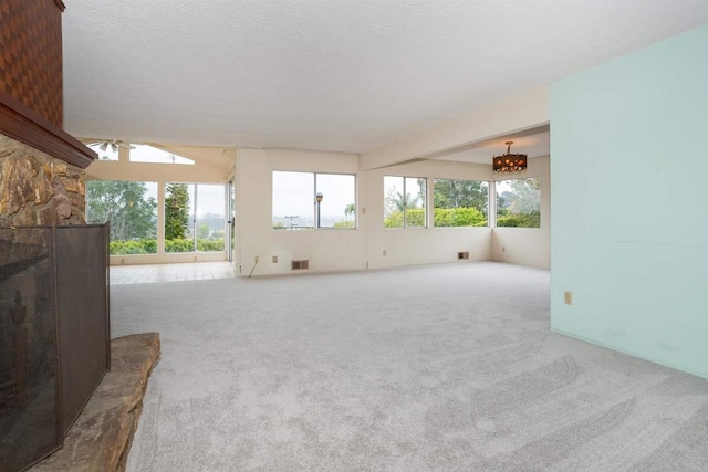 557 Canyon Dr, Solana Beach, CA 92075 - unfurnished living room with carpet, a chandelier, a stone fireplace, and a ceiling fan