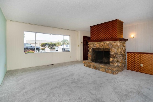 557 Canyon Dr, Solana Beach, CA 92075 - unfurnished living room featuring a stone fireplace, carpet floors, a textured ceiling, and wooden walls
