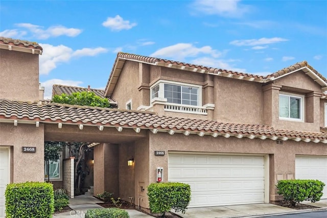 view of front facade with an attached garage, driveway, and stucco siding