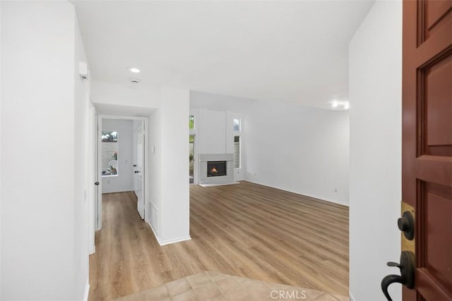 interior space featuring recessed lighting, light wood-style flooring, and a fireplace