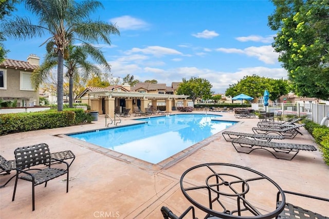 community pool featuring a patio area and fence
