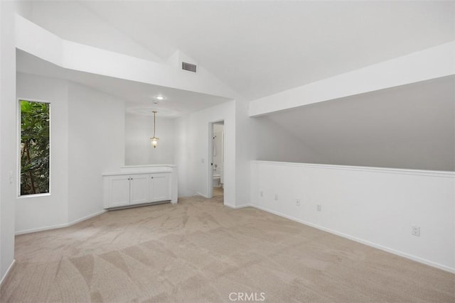 bonus room featuring visible vents, baseboards, vaulted ceiling, and light carpet