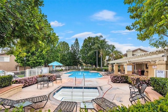 community pool featuring fence, a community hot tub, and a patio area
