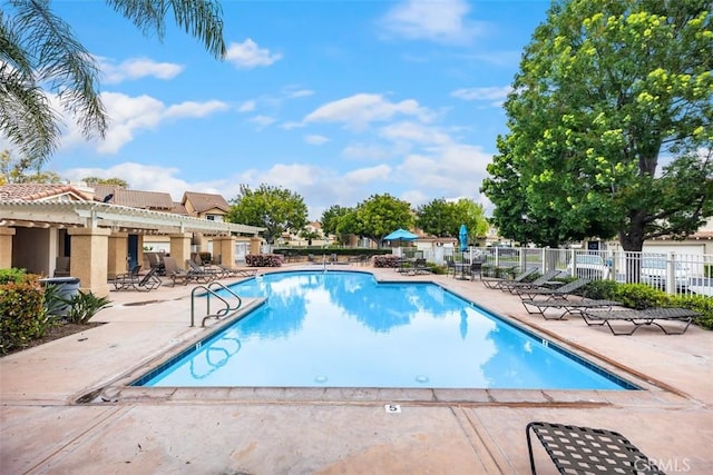 pool with a patio and fence