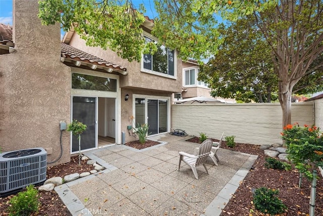 back of house featuring a tile roof, stucco siding, a fenced backyard, central air condition unit, and a patio