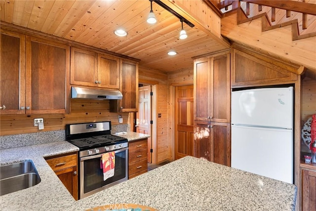 12352 Centerville Rd, Chico, CA 95928 - kitchen with stainless steel gas range oven, under cabinet range hood, freestanding refrigerator, wood ceiling, and a sink