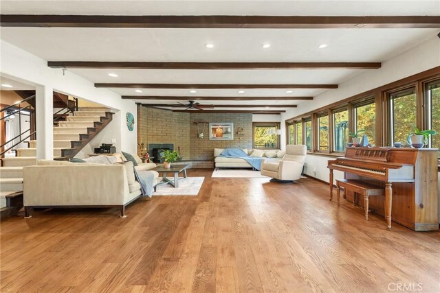 12352 Centerville Rd, Chico, CA 95928 - living room featuring light wood-type flooring, a ceiling fan, stairs, a brick fireplace, and beamed ceiling