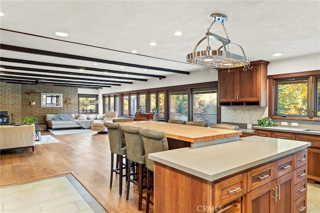 12352 Centerville Rd, Chico, CA 95928 - kitchen featuring recessed lighting, light countertops, a kitchen island, a breakfast bar, and brown cabinets