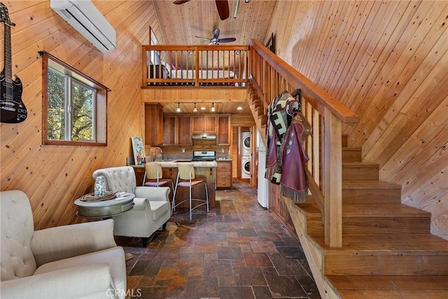 12352 Centerville Rd, Chico, CA 95928 - living room with stacked washer / drying machine, stone tile flooring, a wall mounted air conditioner, ceiling fan, and wooden walls