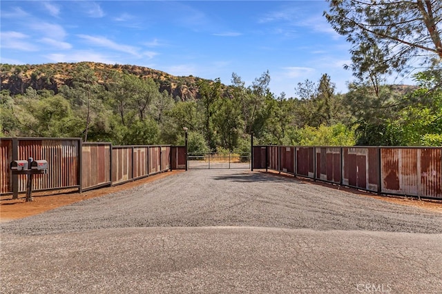 12352 Centerville Rd, Chico, CA 95928 - view of dirt / gravel road featuring a gate, a mountain view, a forest view, and a gated entry